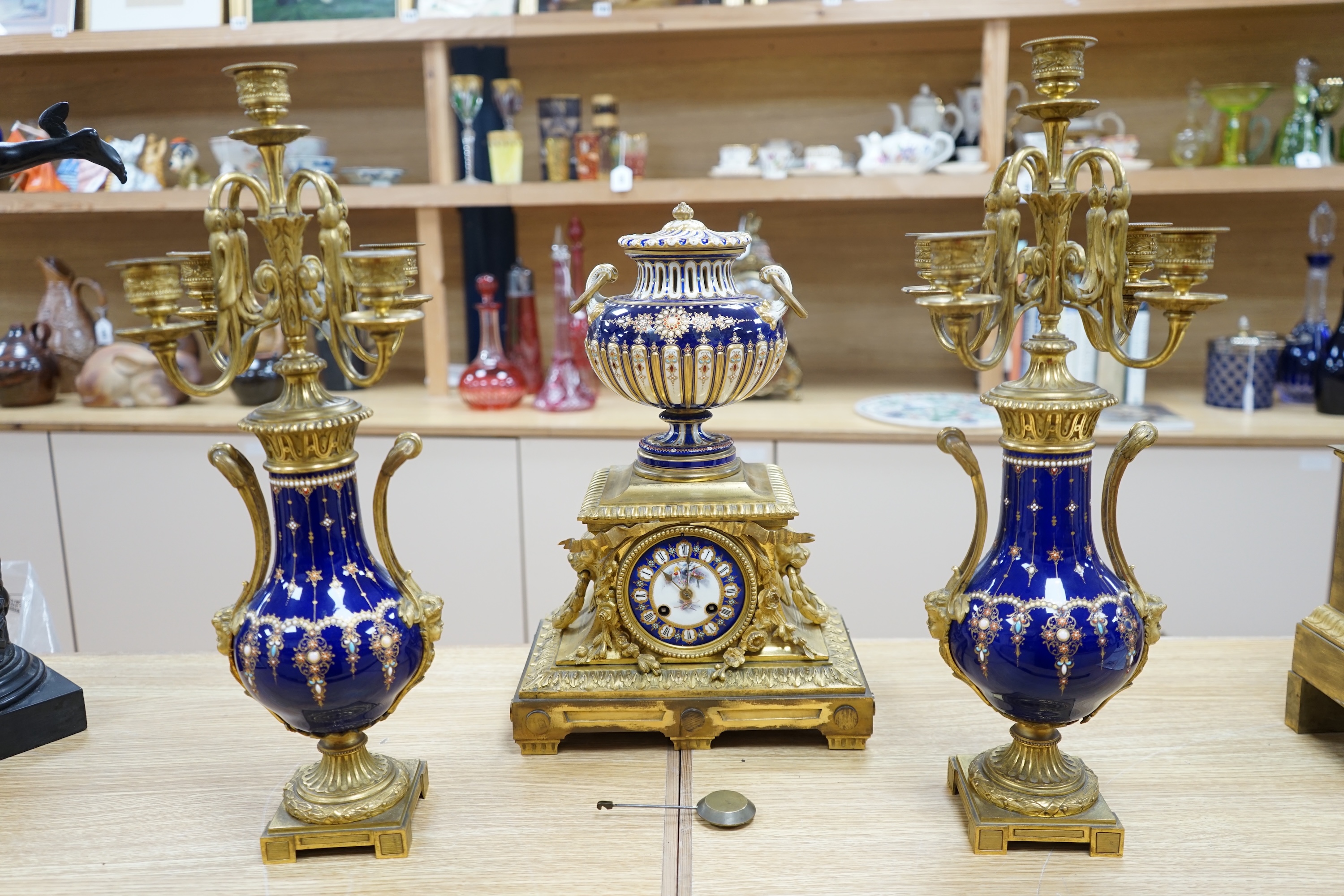 A 19th century Sevres style jewelled porcelain and ormolu matched clock garniture, striking on a bell, with pendulum, 51cm high. Condition - fair to good, minor restoration, untested